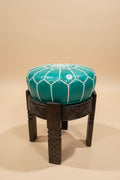 pouf en cuir marocain sur tabouret en bois sculpté